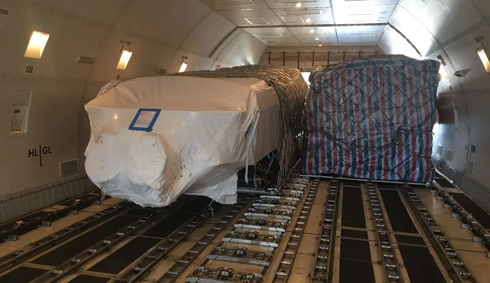 Wrapped boat strapped down on the main deck inside a 747 freighter
