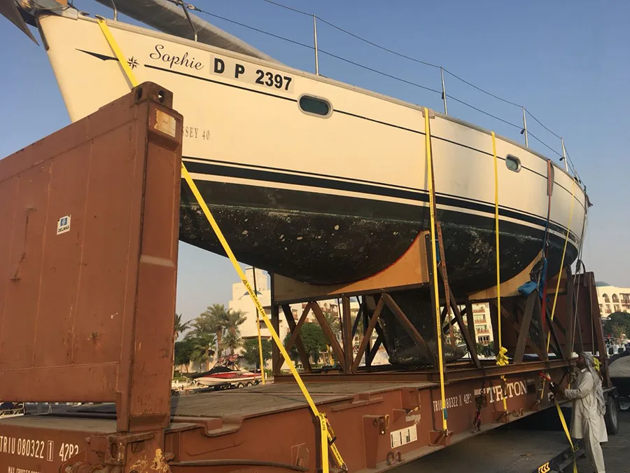 Sailing yacht on a steel cradle strapped down on a 40 ft flat rack container