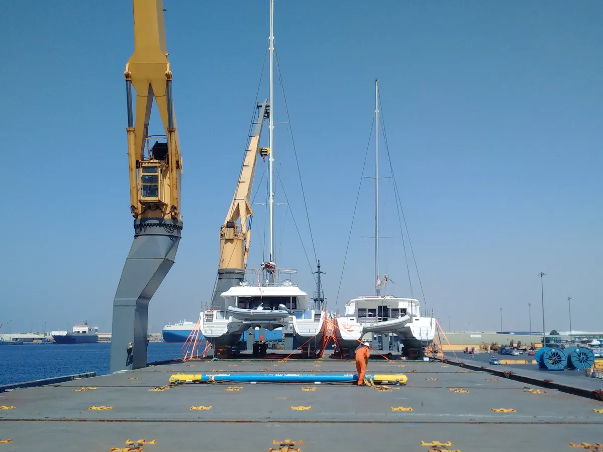 Two sailing catamarans standing on deck after loading