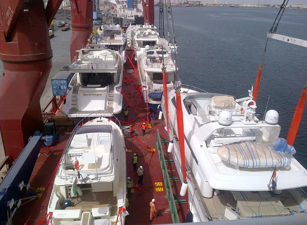Row of motor yachts on the deck of a cargo ship alongside in Dubai