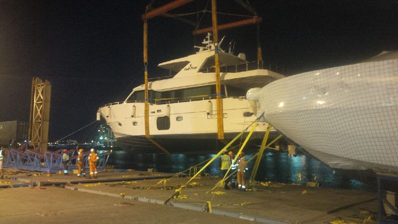 Yacht on a lowbed truck being prepared for road transport to Kuwait