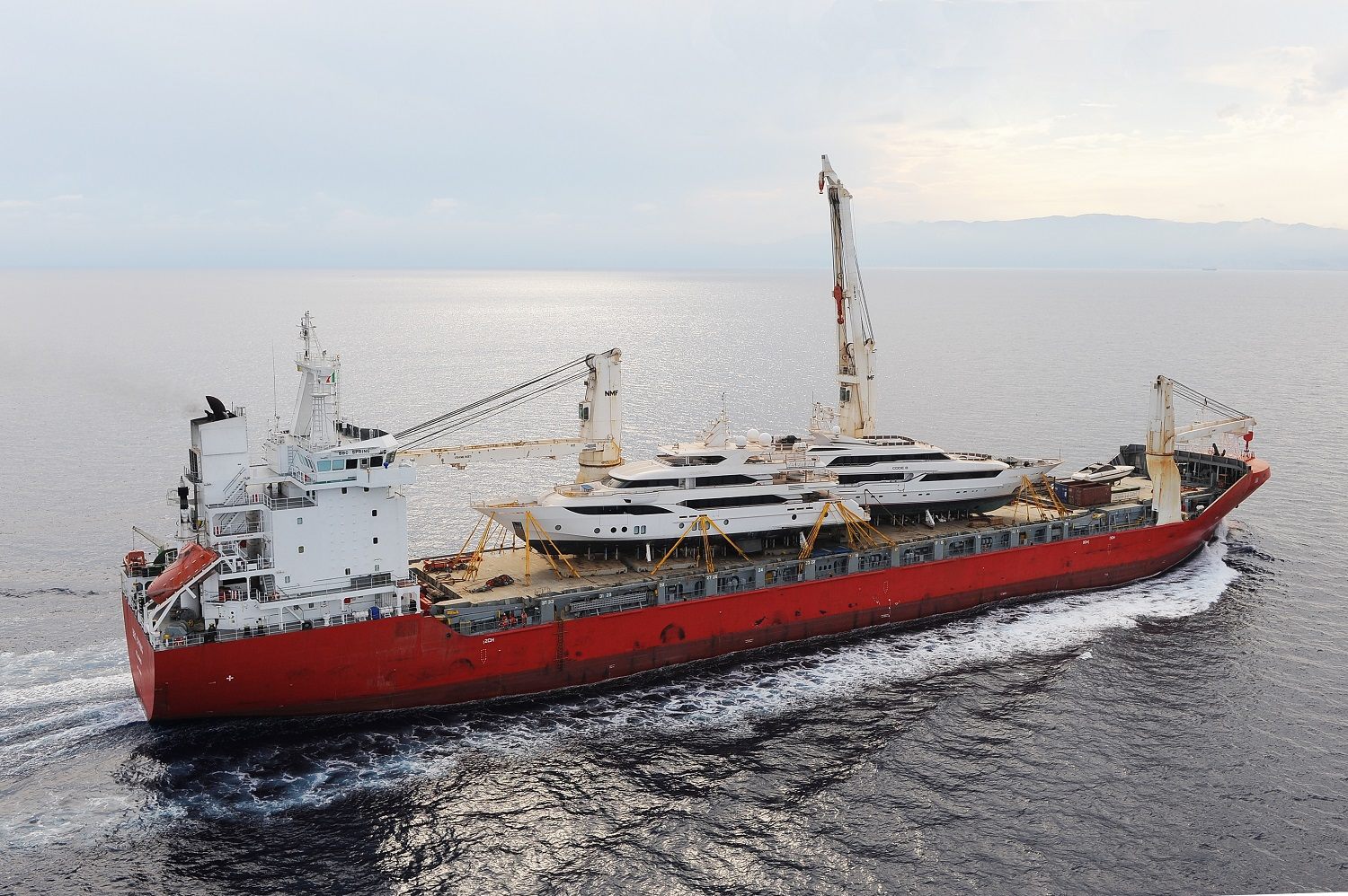 Superyacht carried on the deck of a cargo ship for transport to the Maldives