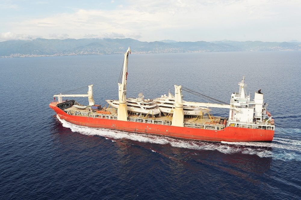 Cargo ship at sea carrying yachts on deck for transport to the Maldives