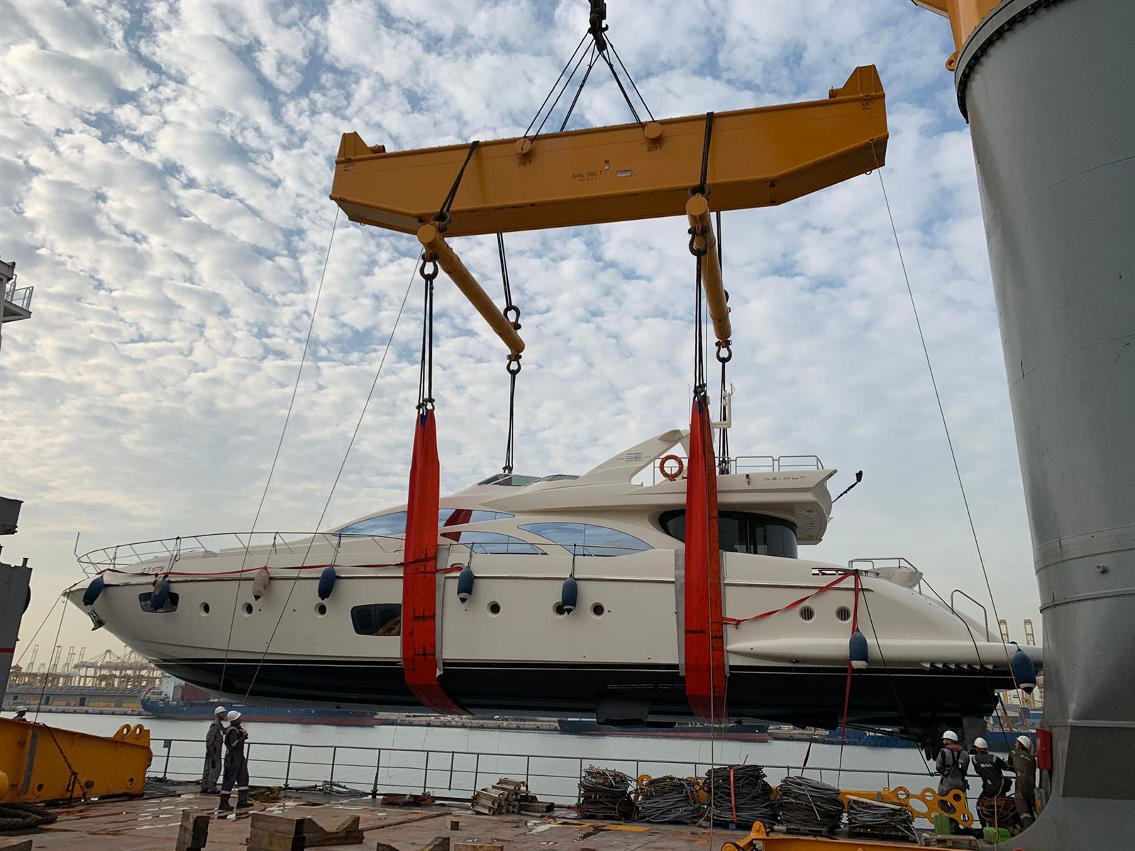 Motor yacht lifted with a spreader bar during loading for yacht transport to Oman