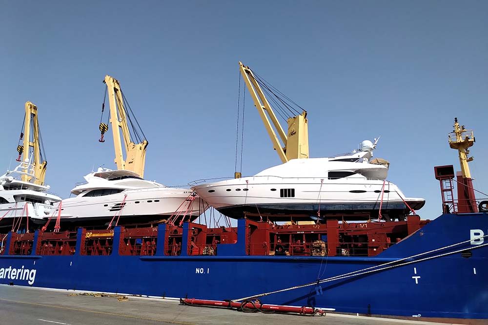 Motor yacht lifted in soft slings during loading for transport to Phuket