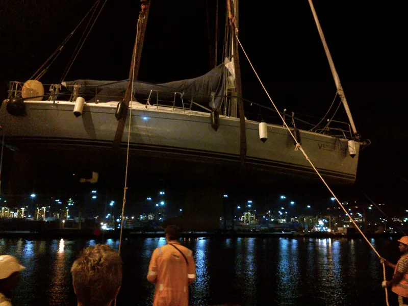 Sailing yacht lifted at night in a lit port