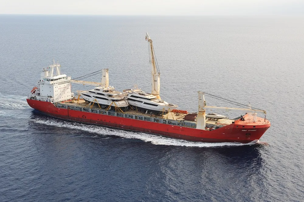 Heavy lift ship at sea carrying superyachts on deck