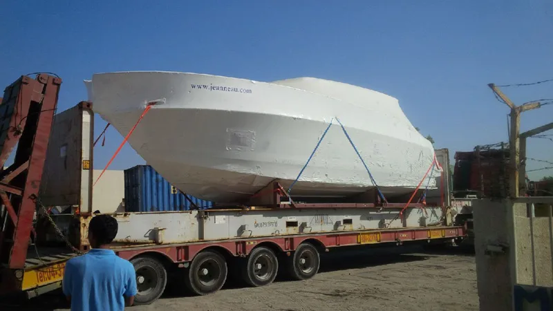 Yacht on its cradle on a four-axle trailer, ready to leave the port
