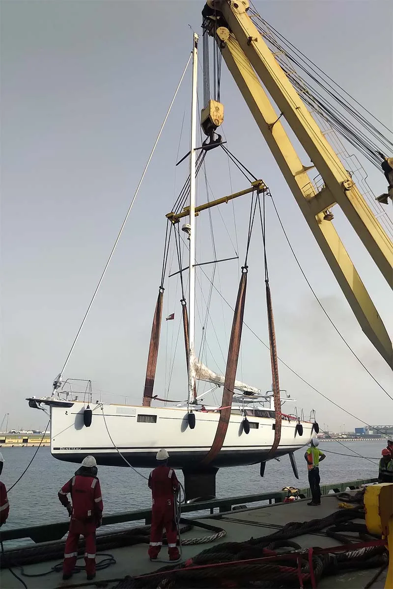 Sailing yacht hanging in slings, keel and rudder in full view during the lift